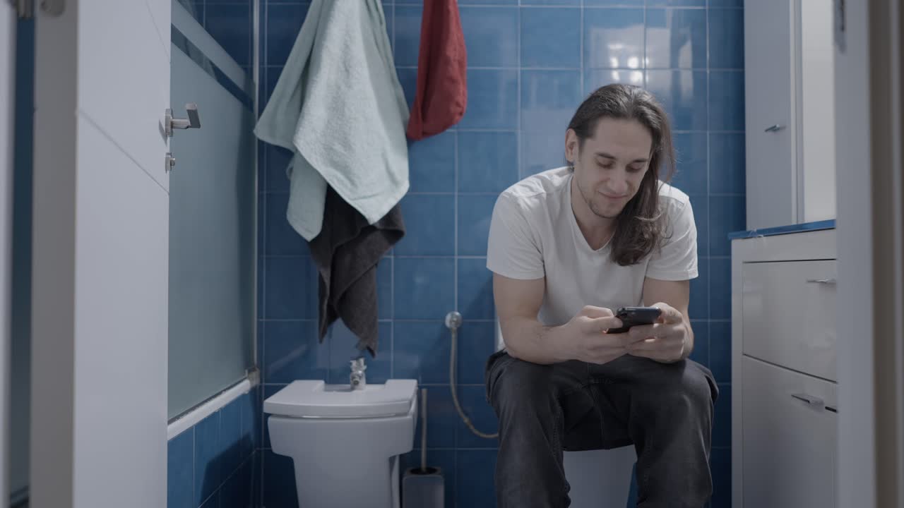 hombre usando el teléfono en un baño