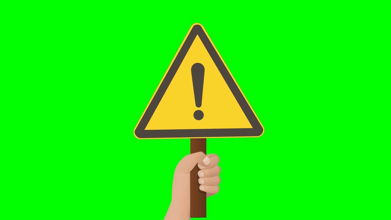 A hand holds up a warning sign on green background