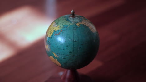 Vintage-Globe-on-Wooden-Base-Bathed-in-Sunlight-Reflections