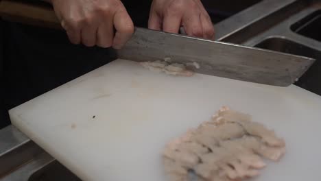 close up of chef chopping fish in a sushi restaurant