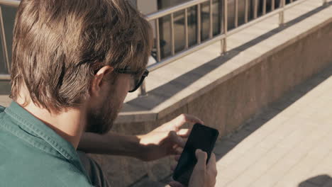 hombre usando un teléfono inteligente al aire libre