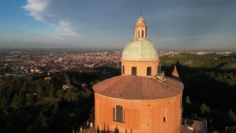 drone view of sanctuary of madonna di san luca overlooking bologna at sunset