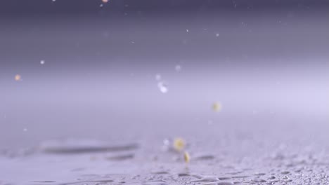 close-up slowmotion slicing a red paprika pepper with a cleaver on wet table top