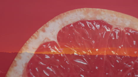 composition of halved grapefruit and sunset on red background