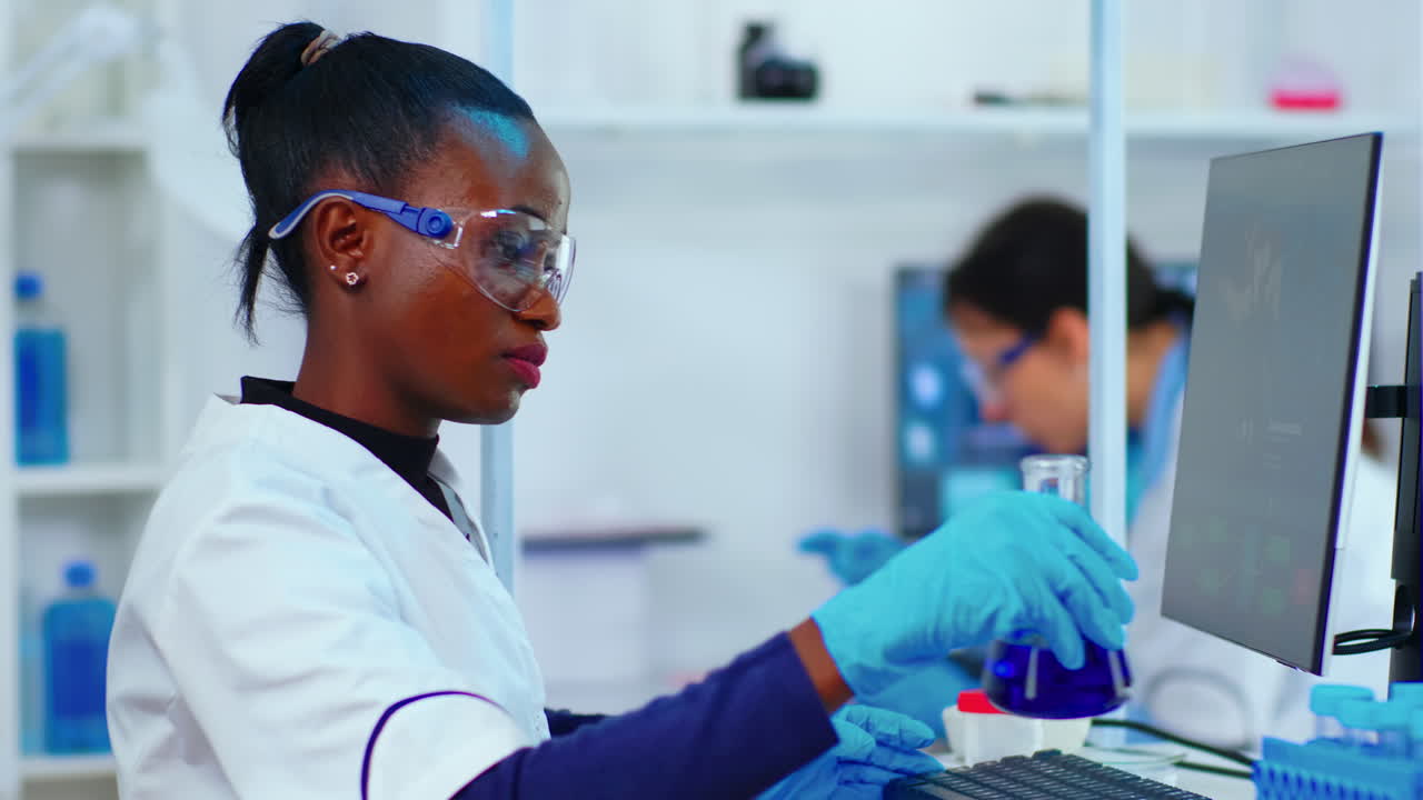 Black woman biologist researching using computer