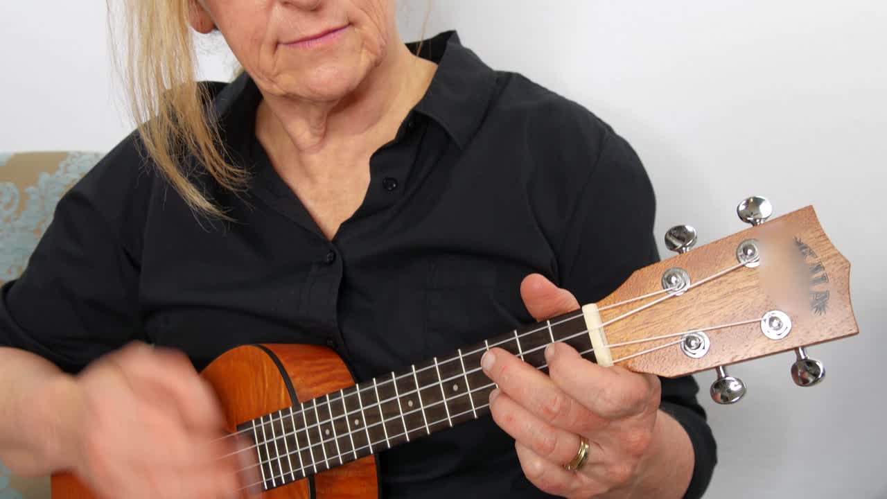 vista de cerca de una mujer tocando el ukelele, inclinada hacia arriba