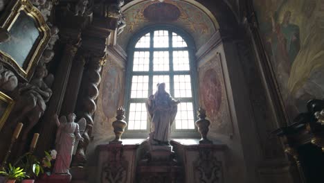 interior of university church of the blessed name of jesus in wrocław, poland, featuring ornate statues and large arched window