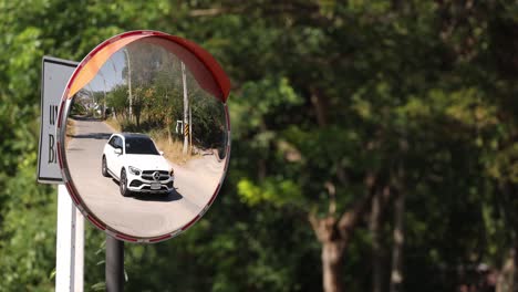 vehicle progression reflected in roadside safety mirror