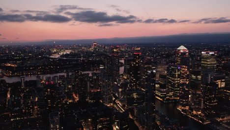 Ascending-footage-of-cityscape-at-dusk.-Evening-aerial-panoramic-view-of-downtown-with-tall-skyscrapers.-London,-UK