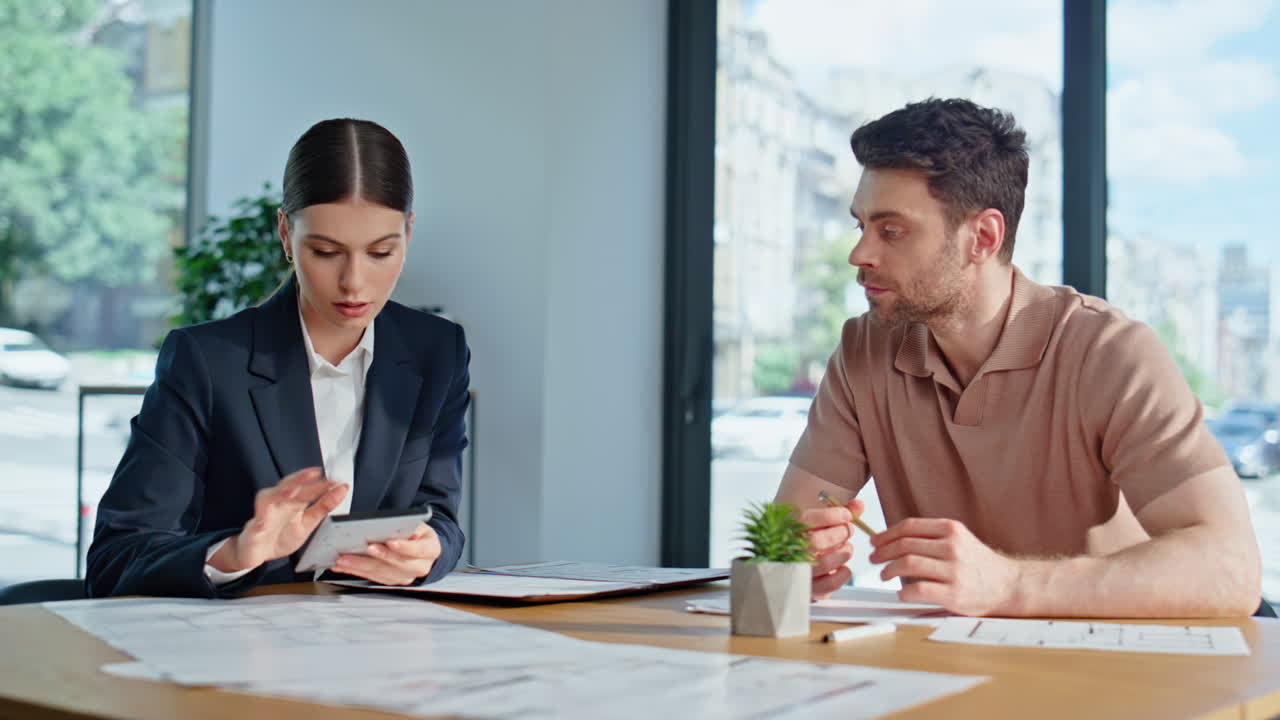 Primer plano de un agente de seguros hablando con un cliente y calculando las ventajas en un escritorio de oficina