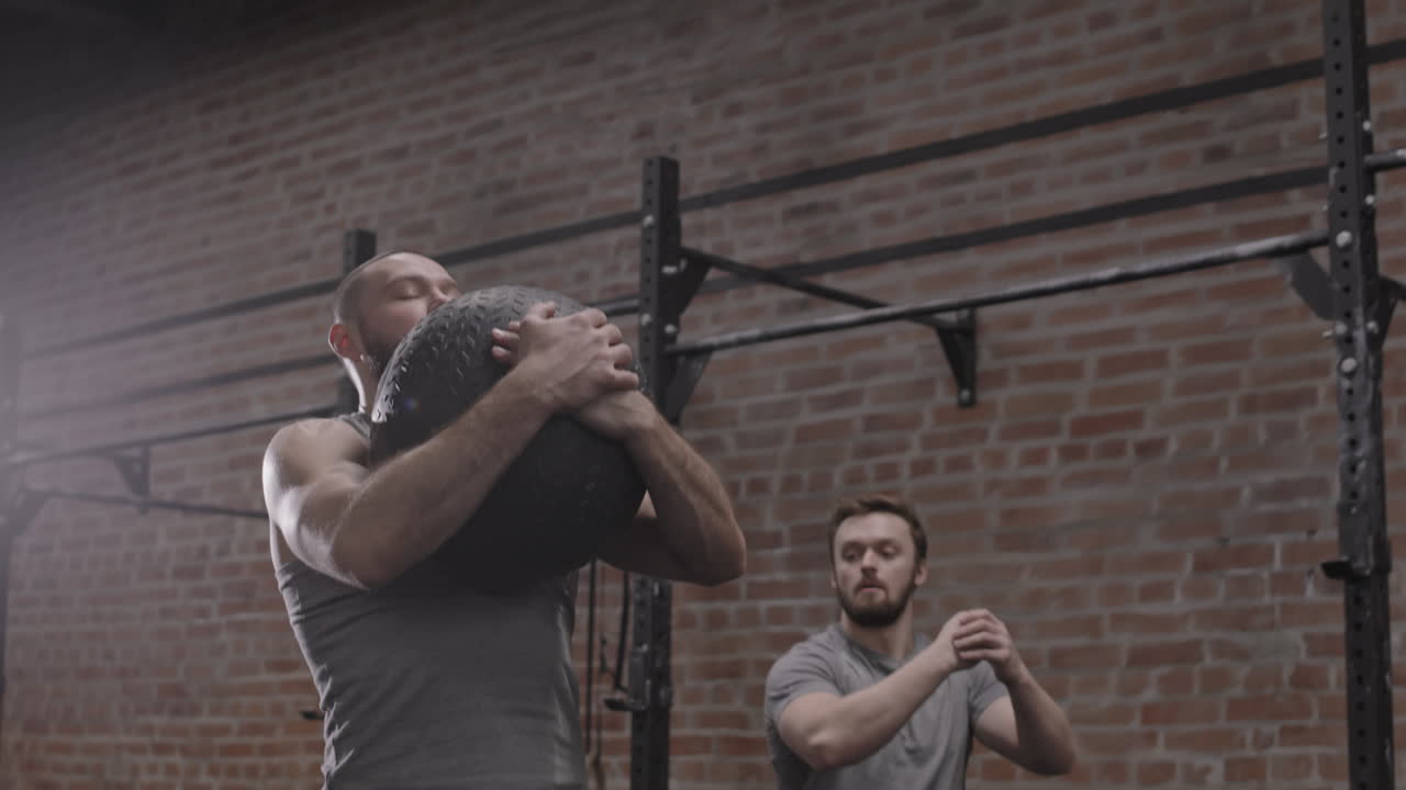 Two Sportsmen Exercising in Gym
