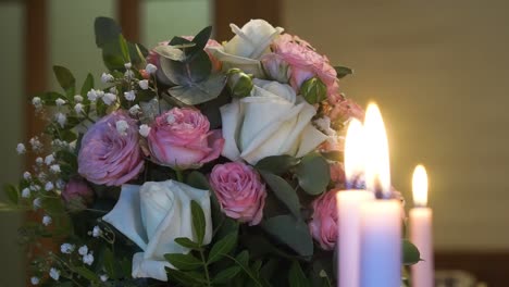 primer plano de velas encendidas en el fondo de un ramo de flores