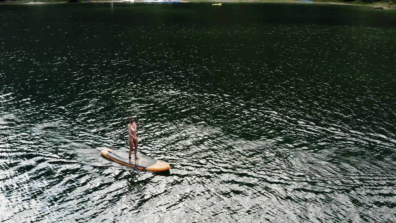 Woman Paddleboarding on a Lake