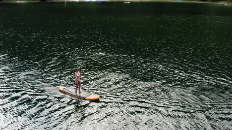 una mujer haciendo paddleboard en un lago.