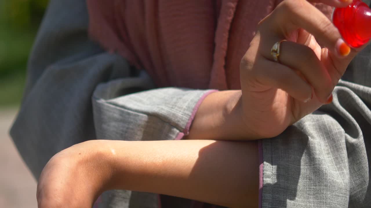 Woman applying facial roller on her arm