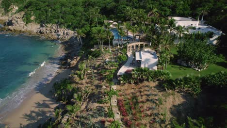 aerial drone view on a sunny day revealing a beautiful beach resort with luxury homes nearby the shore palm trees