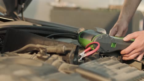 auto service worker checking voltage on car battery. service engineer working in car service station