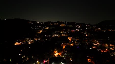 Suburban-neighborhood-of-Hollywood-Hills,-California-at-night---pull-back-aerial-reveal
