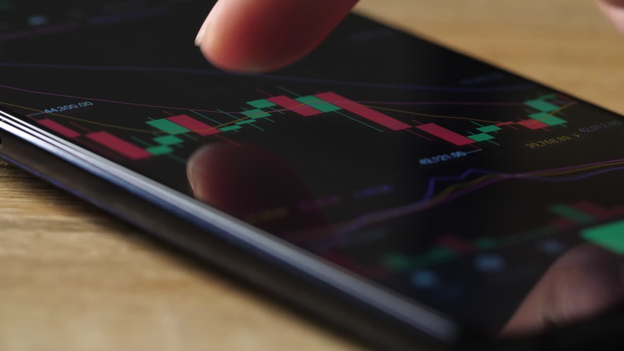 Dito in primo piano che controlla il grafico azionario su smartphone
