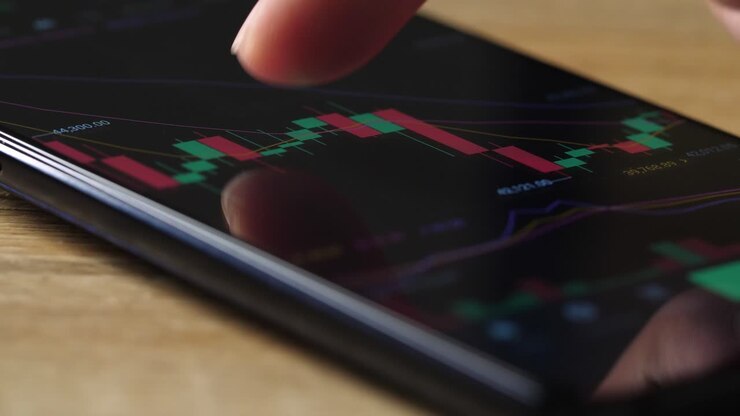 Dito in primo piano che controlla il grafico azionario su smartphone