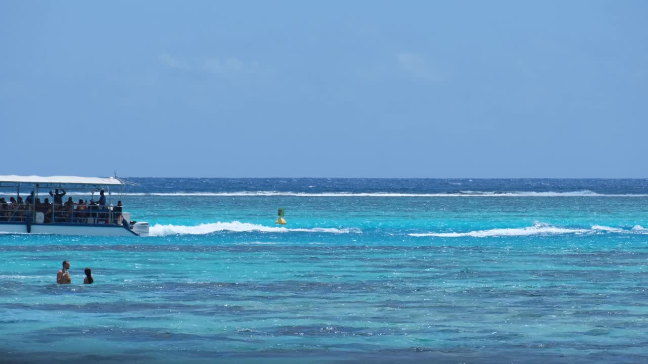 A full tour boat with tourist in crystal clear turquoise lagoon on ...