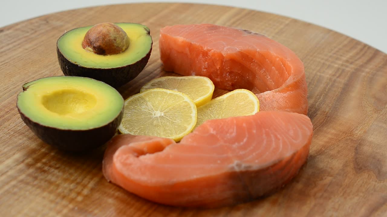 Salmone salato, avocado e limone su un tagliere da cucina. Gustosa natura morta, i prodotti combinati