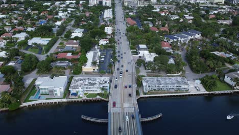 palmetto park rd icw bridge with busy traffic on the east coast of florida from an aerial drone tilting upward revealing the scenic coastline view of the ocean