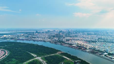 a daytime aerial view of ho chi minh city with the saigon river winding through the urban sprawl reveals a contrast between the dense cityscape and lush greenery. vietnam, uhd.