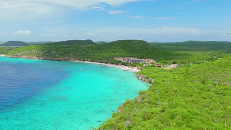 el avión no tripulado vuela sobre el paisaje árido tropical de curaçao mientras las nubes pasan sobre la playa porto mari