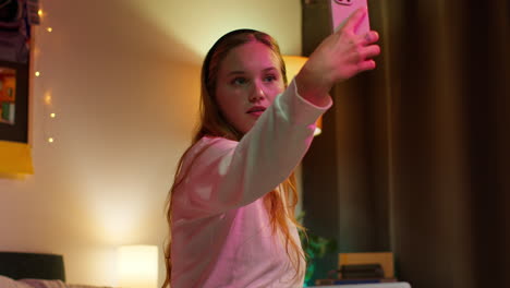 a young woman takes a selfie in her bedroom.