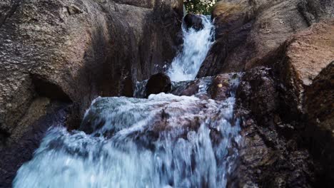 cascada de montaña cristalina en rocas erosionadas en el desierto de cerca