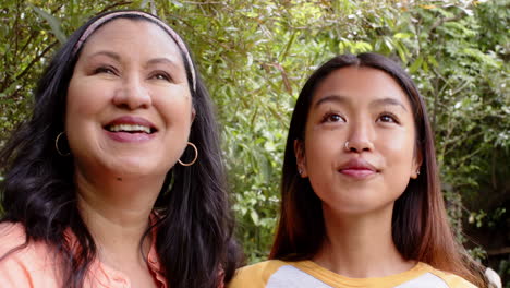 laughing together in garden, multiracial grandmother and young woman