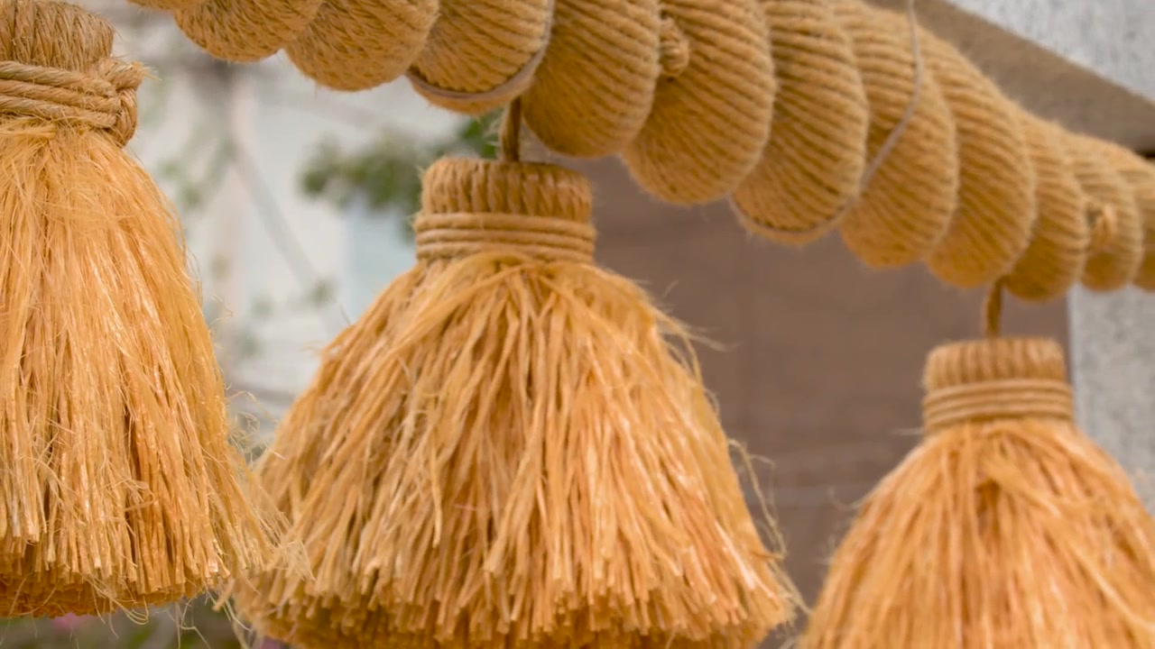 Vista dettagliata di una corda shimenawa intrecciata di paglia di riso appesa a un torii di pietra