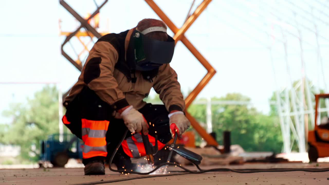 Worker welding metal in an industrial site under sunny sky