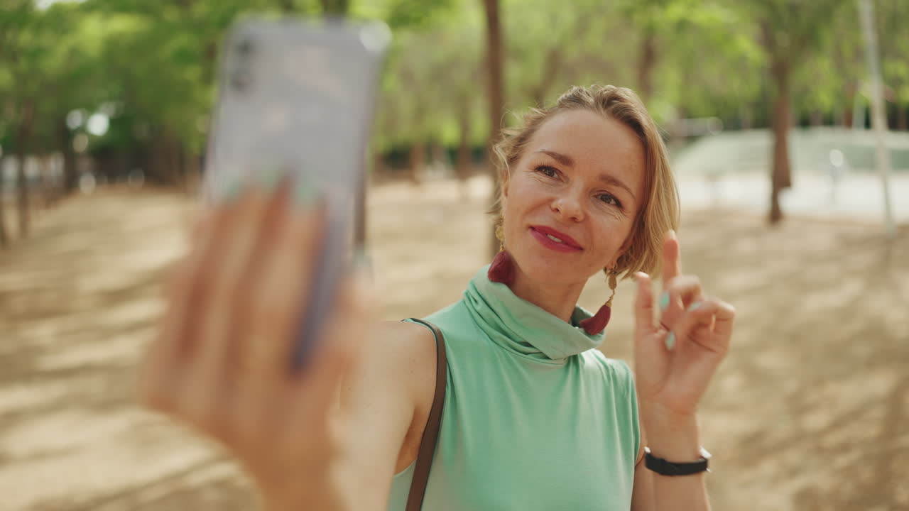Woman taking selfie in park