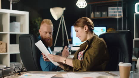 successful woman discussing documents with colleague