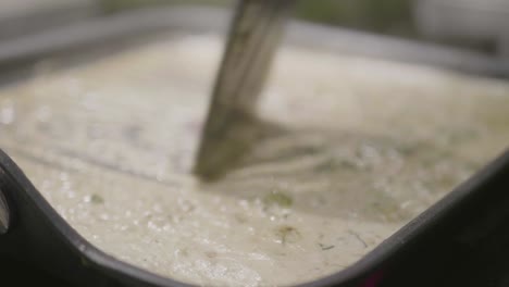 closeup of someone cooking cream sauce in a frying pan