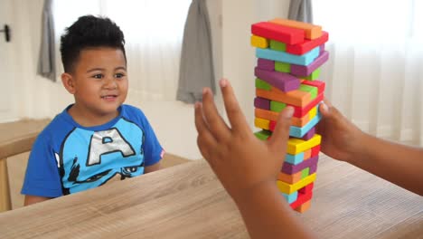 happy boy with falling wood block tower game, slow motion