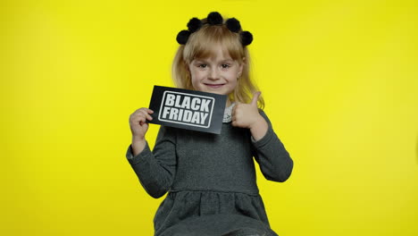 Child-girl-showing-Black-Friday-inscription,-smiling,-looking-satisfied-with-low-prices,-discounts