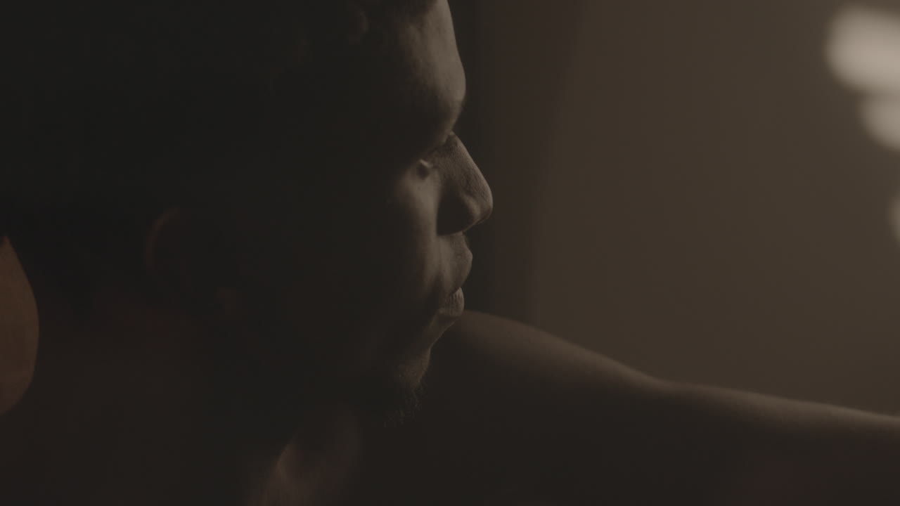 Close-Up of Contemplative Black Man Sitting in Dimly Lit Room