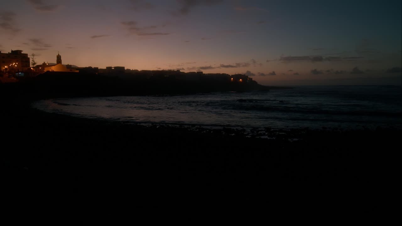 Panoramica, ora blu, onde al rallentatore sulla spiaggia di Beeble a Playa La Caleta de Interián a Tenerife, Isole Canarie
