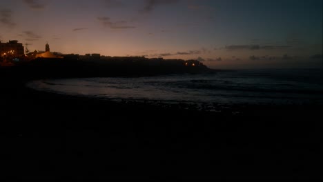 camera pan, blue hour, slowmotion waves on beeble beach in playa la caleta de interián on tenerife, canary islands