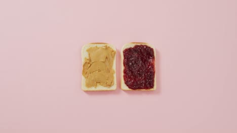 close up view of peanut butter and jelly sandwich with copy space on pink surface