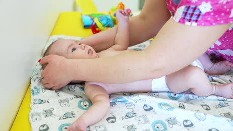 children doctor touches baby boy's head. kid likes the touches and lies peacefully. side view. close up.