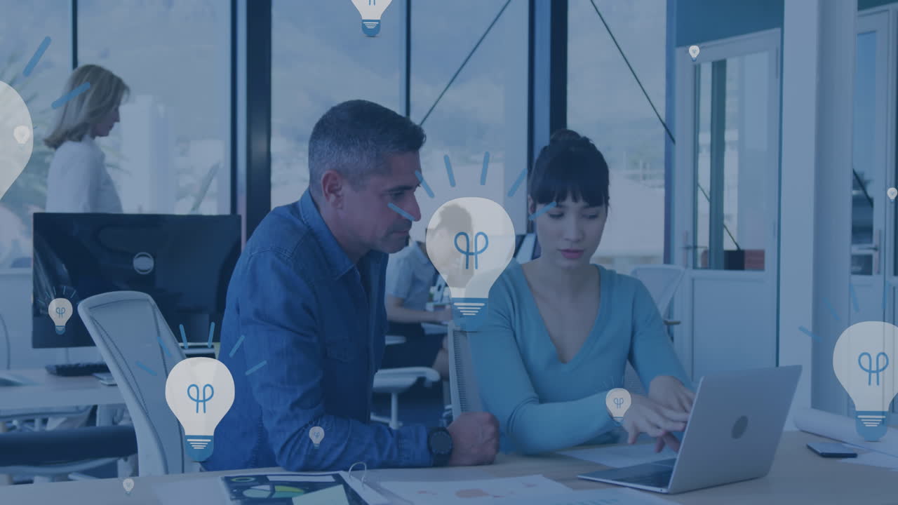 animación de iconos de bombillas eléctricas sobre hombres y mujeres diversos discutiendo sobre una computadora portátil en la oficina