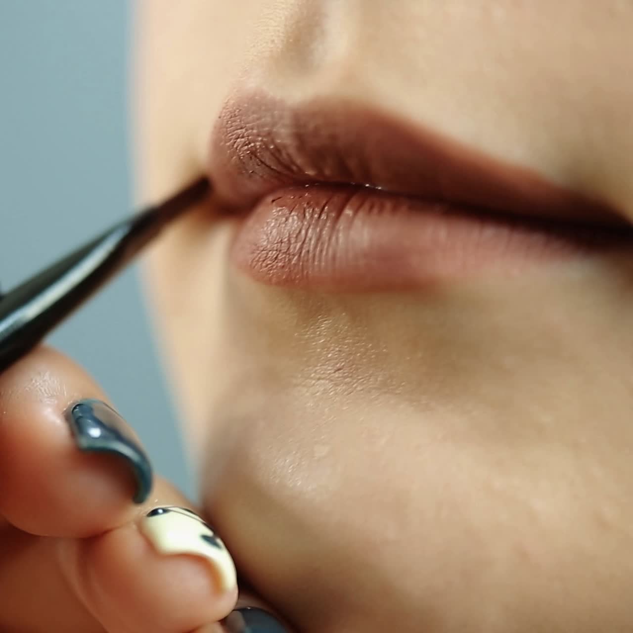 una chica aplicando los labios.