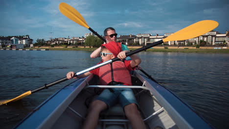 father and son kayaking on a lake