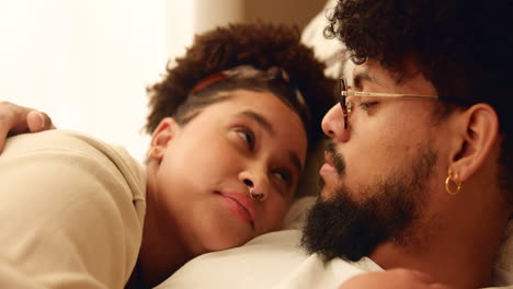 a young couple cuddling in bed together