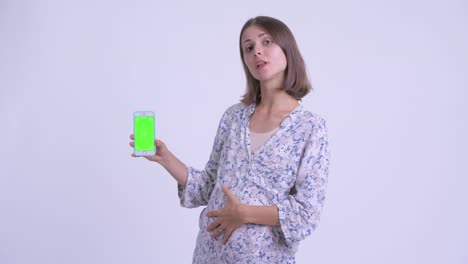 feliz joven hermosa mujer embarazada con teléfono