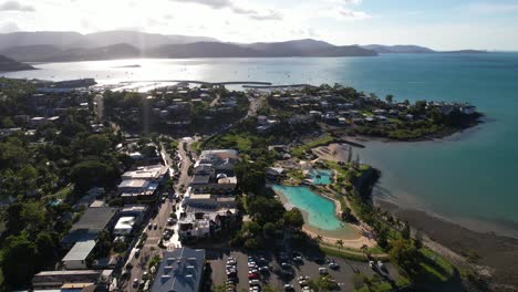 drone shot of airlie beach, queensland, australia, small resort town traffic, marina and waterfront buildings